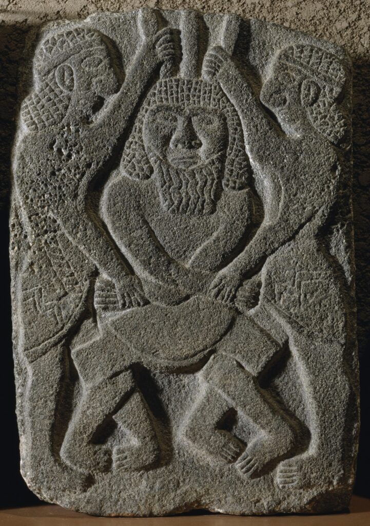 Relief néo-hittite du roi Kapara ( vers  950  - vers  875 avant JC ). Deux héros épinglent un ennemi barbu, tout en saisissant sa coiffe à griffes. Le contexte peut être lié à l'épopée de Gilgamesh et afficher Gilgamesh et Enkidu dans leur combat contre Humbaba. 