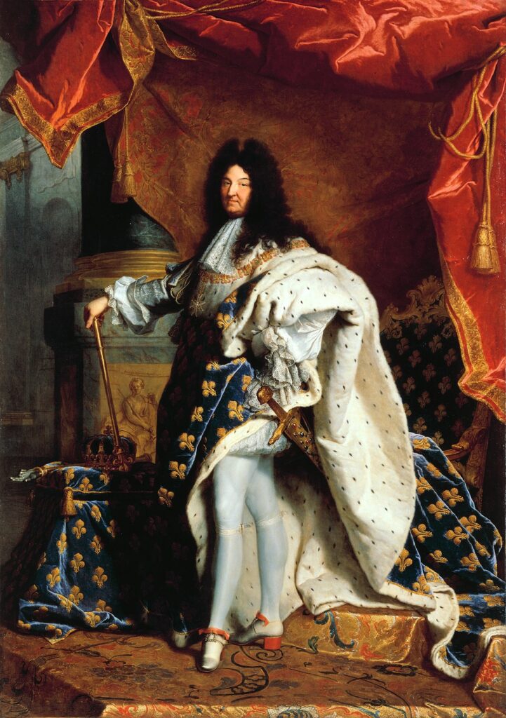 Portrait de Louis XIV en costume de sacre. (Musée du Louvre, huile sur toile, Hyacinthe Rigaud, 1701). (Visite du château de Versailles et de ses jardins !). Crédit photo wikimedia commons.