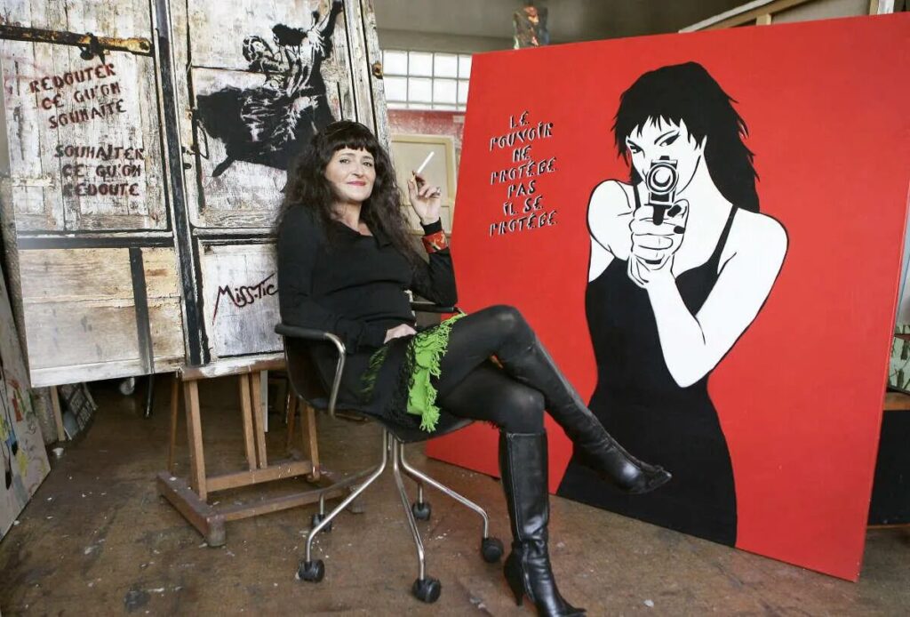 Miss Tic en 2003, devant une de ses œuvres sur support mobile. Crédit photo Bertrand Guay, AFP. (Le Street Art en deuil après la disparition de Miss. Tic. !).